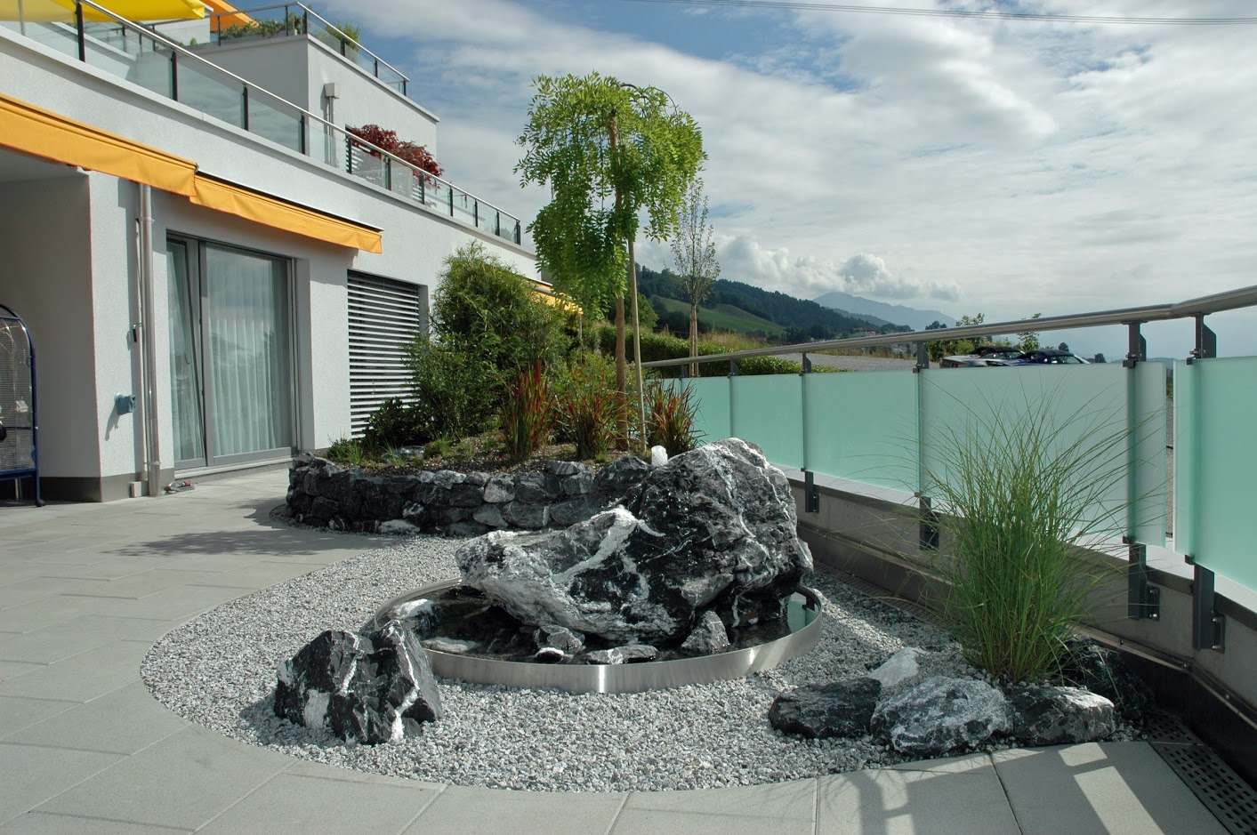 Terrasse mit Findling und Kies