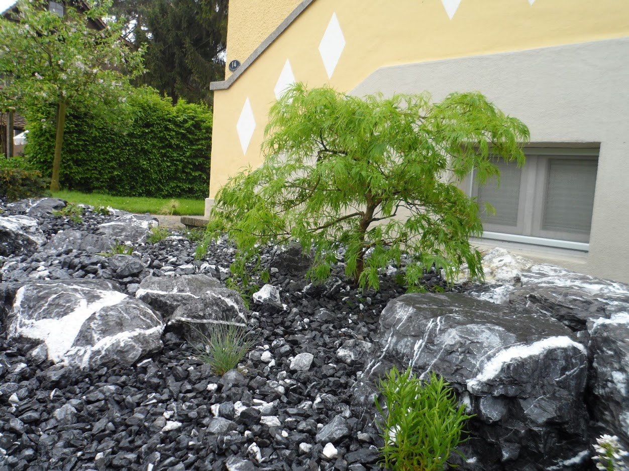 Steingarten mit dunklen Findlingen